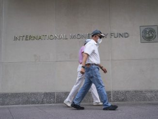 People walk past the headquarters of the International Monetary Fund (IMF) in Washington D.C., the United States, July 17, 2020. (Xinhua/Liu Jie)