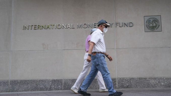 People walk past the headquarters of the International Monetary Fund (IMF) in Washington D.C., the United States, July 17, 2020. (Xinhua/Liu Jie)